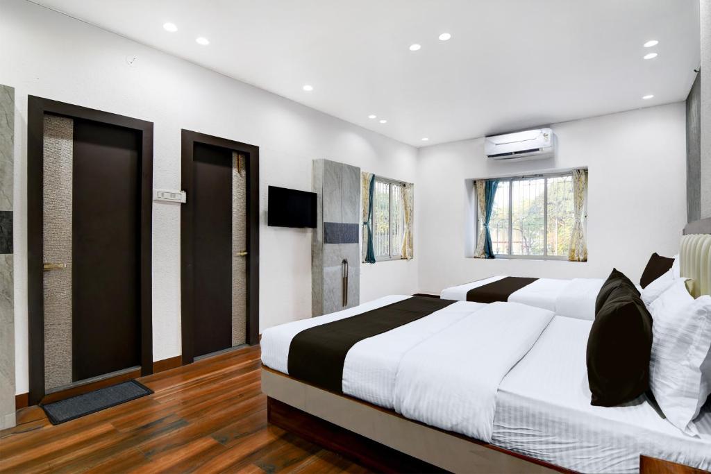 Un dormitorio blanco con una cama grande y ventanas en Hotel O Aditi Guest House, en Salt Lake City