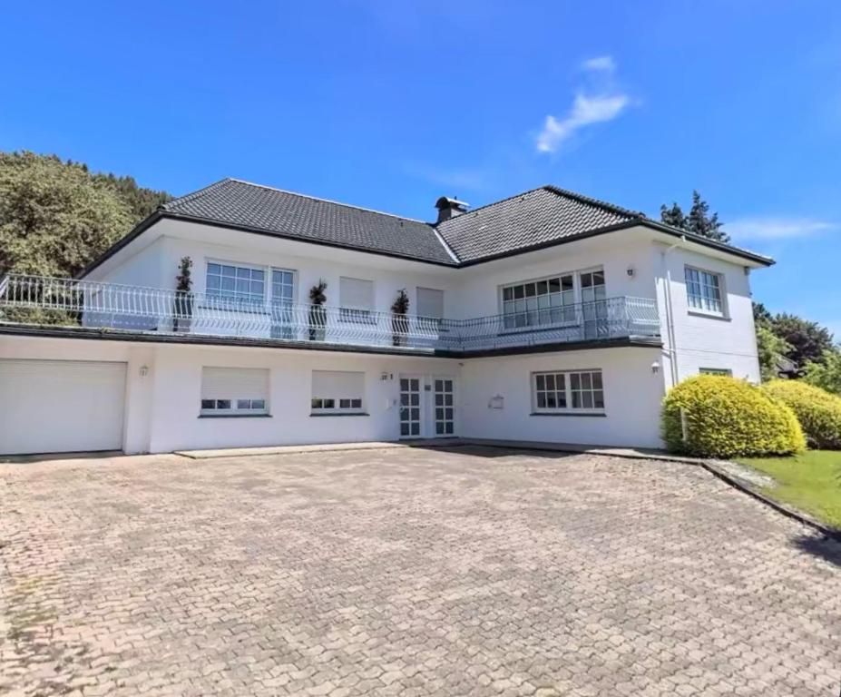 a large white house with a large driveway at Bergapartment I Küche I Bad I Netflix I Disney in Bad Oeynhausen