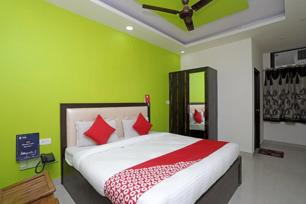 a bedroom with a bed with a green wall at Super Hotel O Raj Palace in Meerut