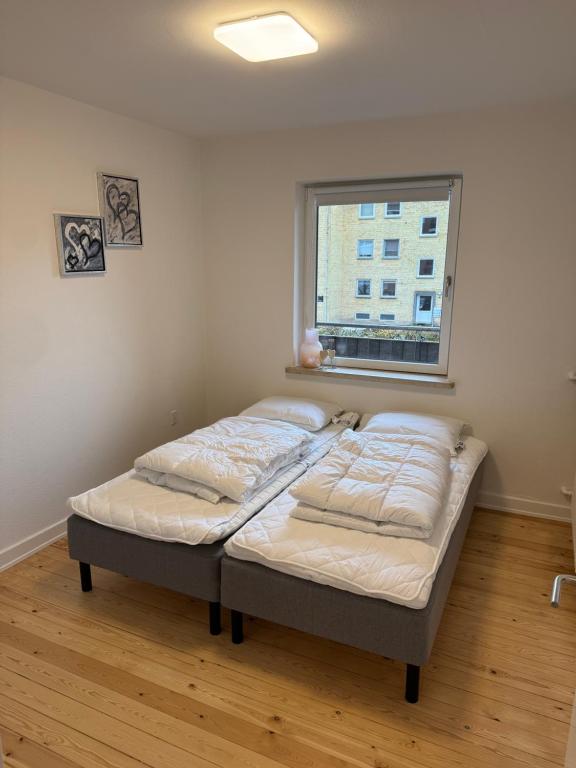 a bed in a room with a window at Flot 3 værelses lejlighed - op til 6 personer in Randers