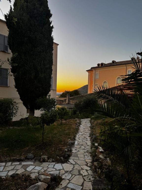 a stone path leading to a building with a sunset in the background at La Terrazza in Tivoli