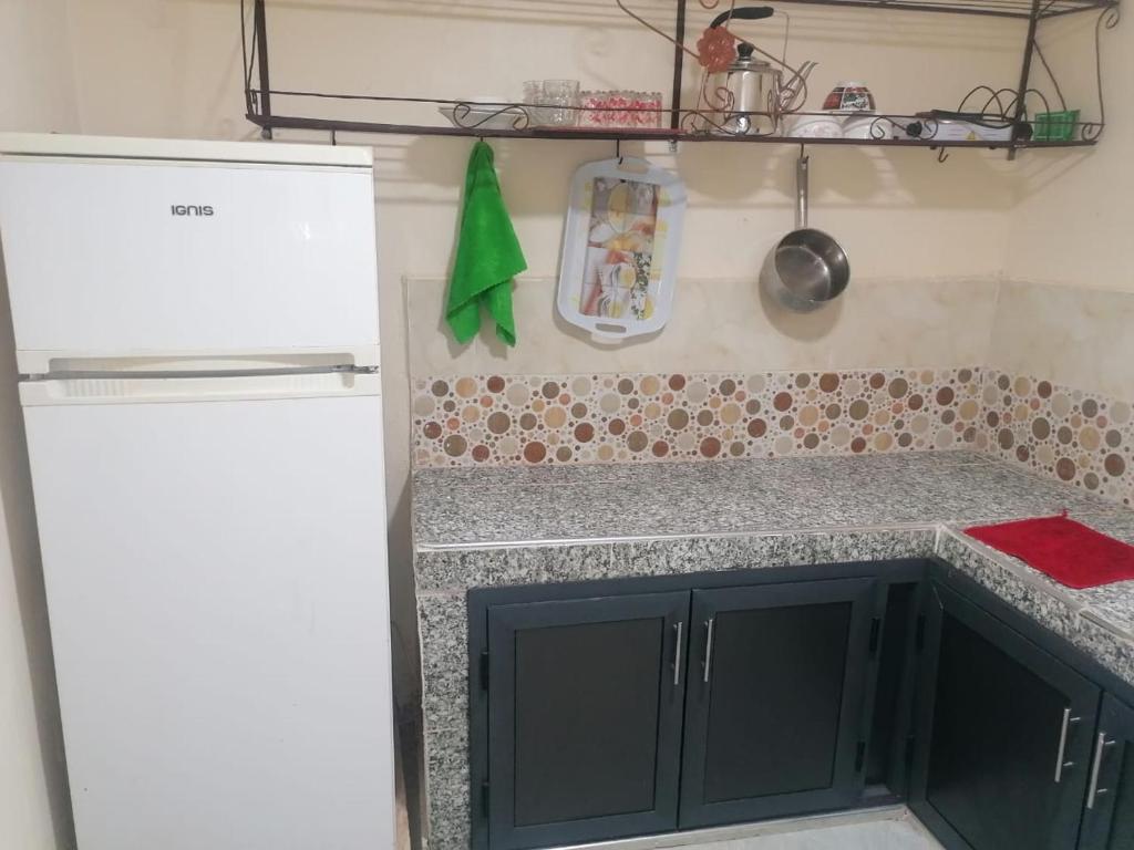 a kitchen with a refrigerator and a counter top at شقة مريحة بجانب مطار المسيرة اكادير in Ikhorbane