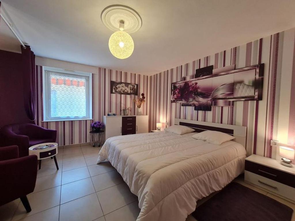 a bedroom with a large bed and a living room at Gîte du Gué in Choloy