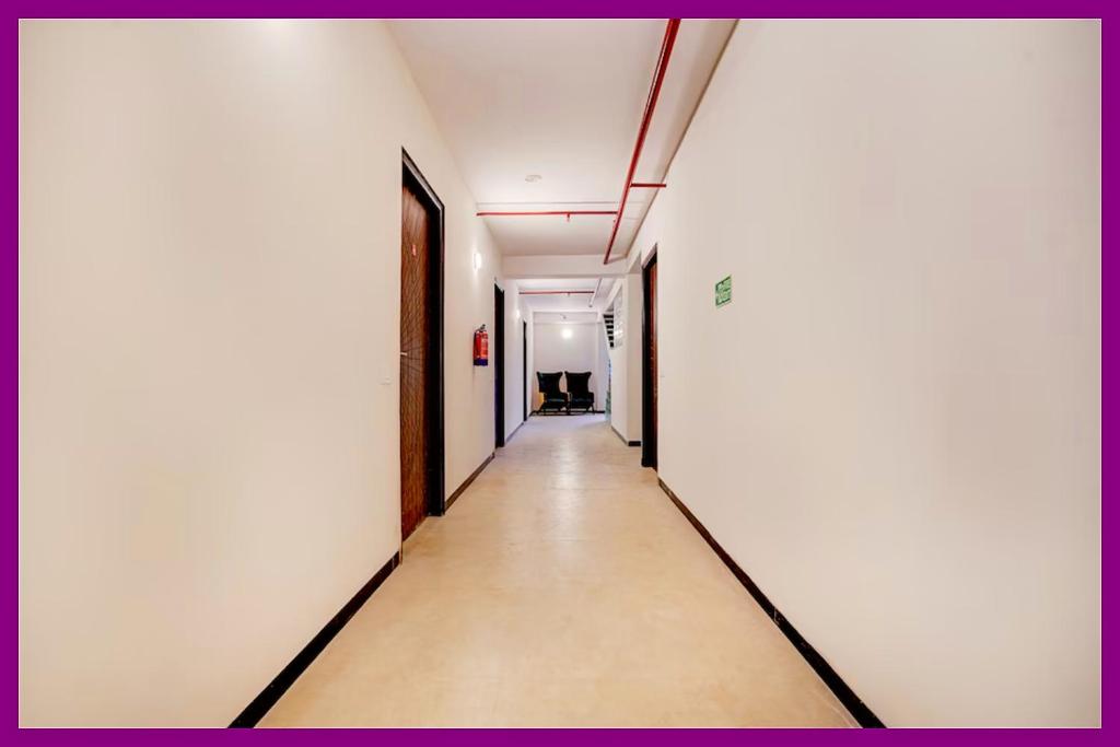 un couloir vide dans un immeuble de bureaux aux murs blancs dans l'établissement Hotel RGH Palace Inn NEAR VISHWANATH TEMPLE # Fully Air Conditioning Luxuary Hotel, à Varanasi