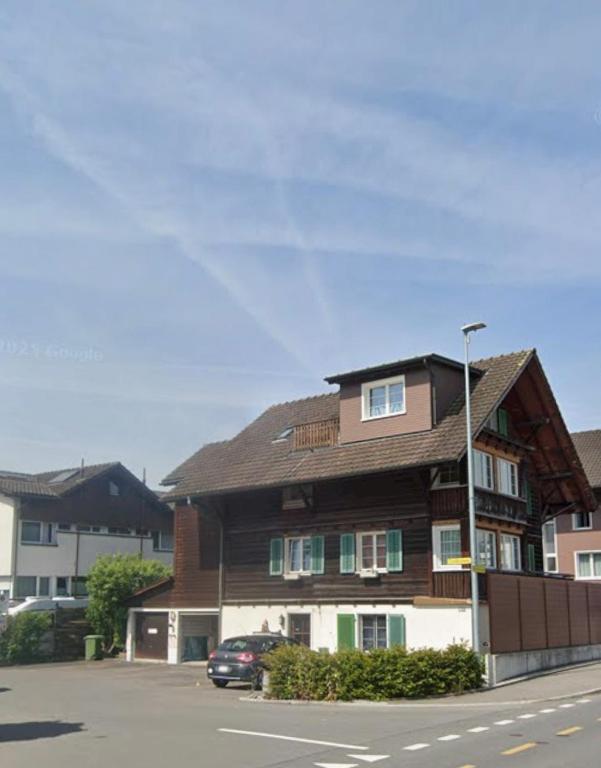 a building on the side of a street with a car at Lakeberry Apartment in Freienbach