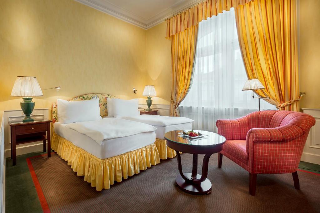 a hotel room with a bed and a chair at Le Palais Art Hotel Prague in Prague