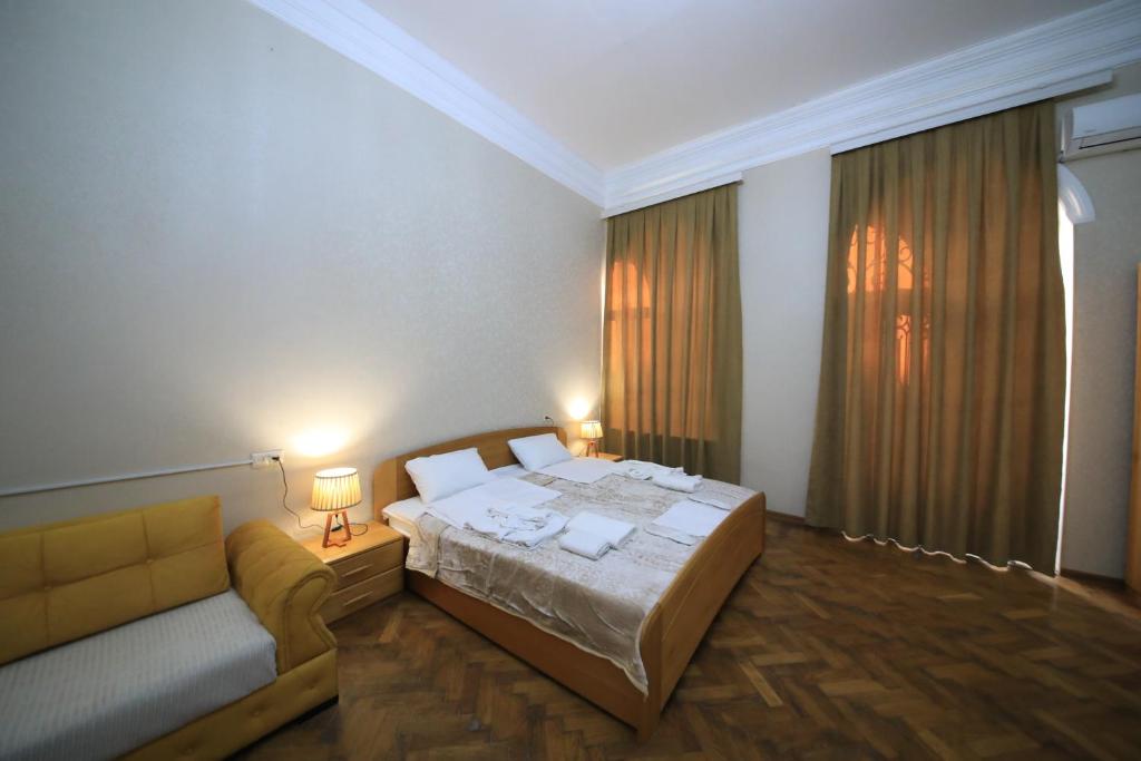 Un dormitorio con una cama y un sofá. en Gallery inn, en Kutaisi