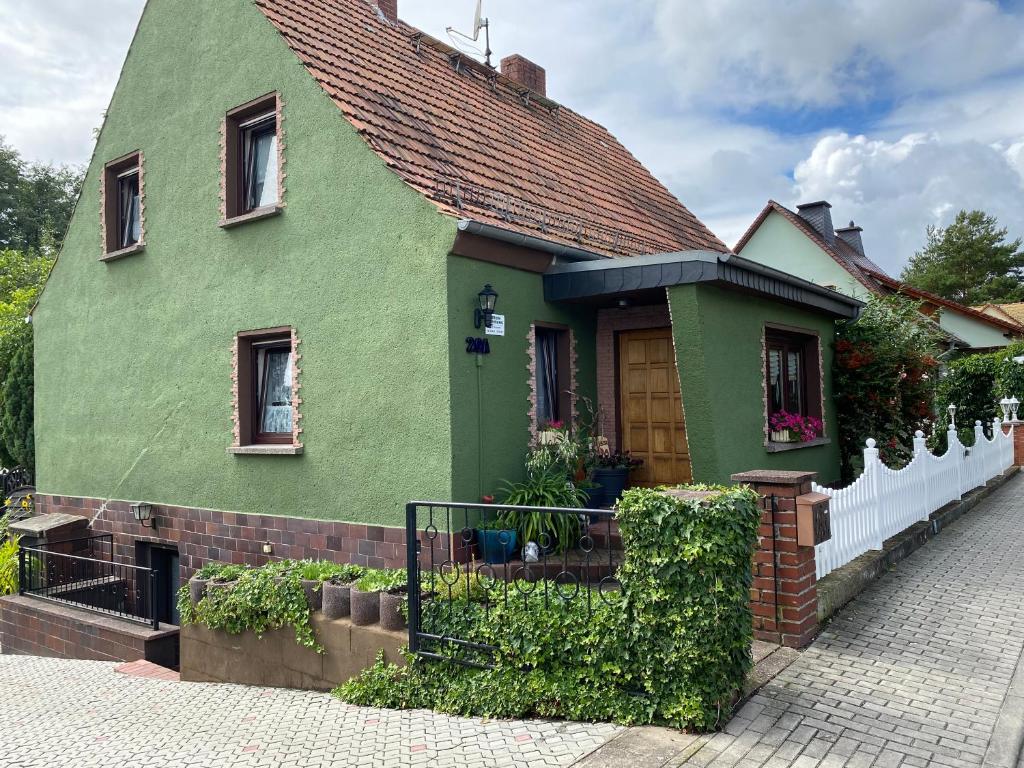 a green house with a red roof at Ferienwohnung Kresse 