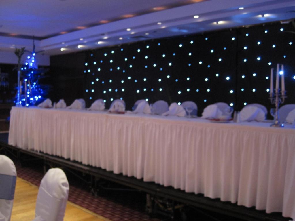 a long table with white chairs in a room with lights at Ashbourne House Hotel in Ashbourne