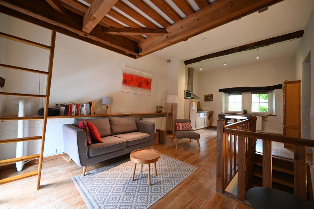 a living room with a couch and a table at Le Nid d'à côté in Méan