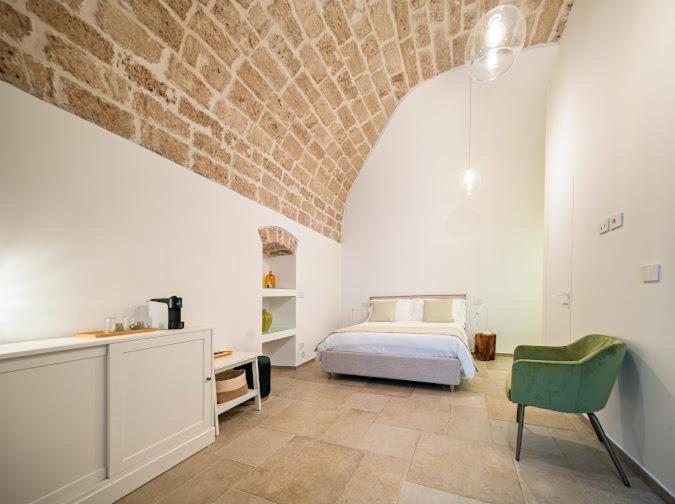 a bedroom with a bed and a brick wall at SuiteLab in Palo del Colle
