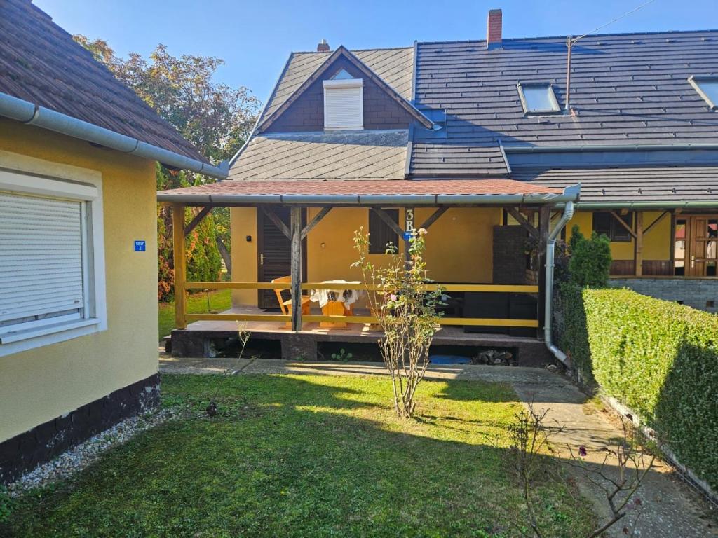 une maison avec un chien assis sur une terrasse couverte dans l'établissement Haus Sissy, à Balatonkeresztúr