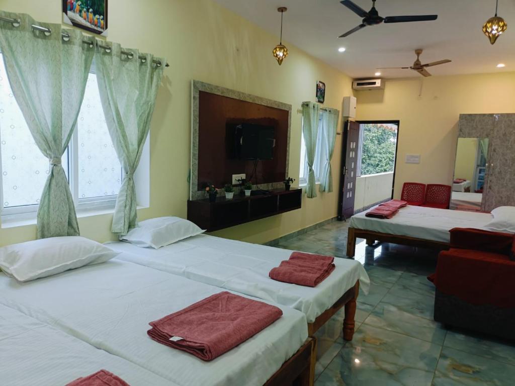 1 Schlafzimmer mit 2 Betten, einem TV und einem Sofa in der Unterkunft Pure Vegeterian 1BHK Private Guest House - Air Cnditioned - WiFi - Full Kitchen - No Alcohol Zone - Hilltop Heaven in Yelagiri