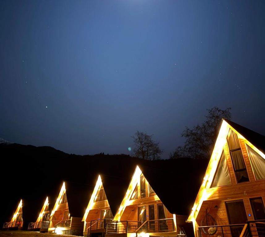 a row of houses with lights on them at night at Mestia POV Luxury Cabins in Mestia