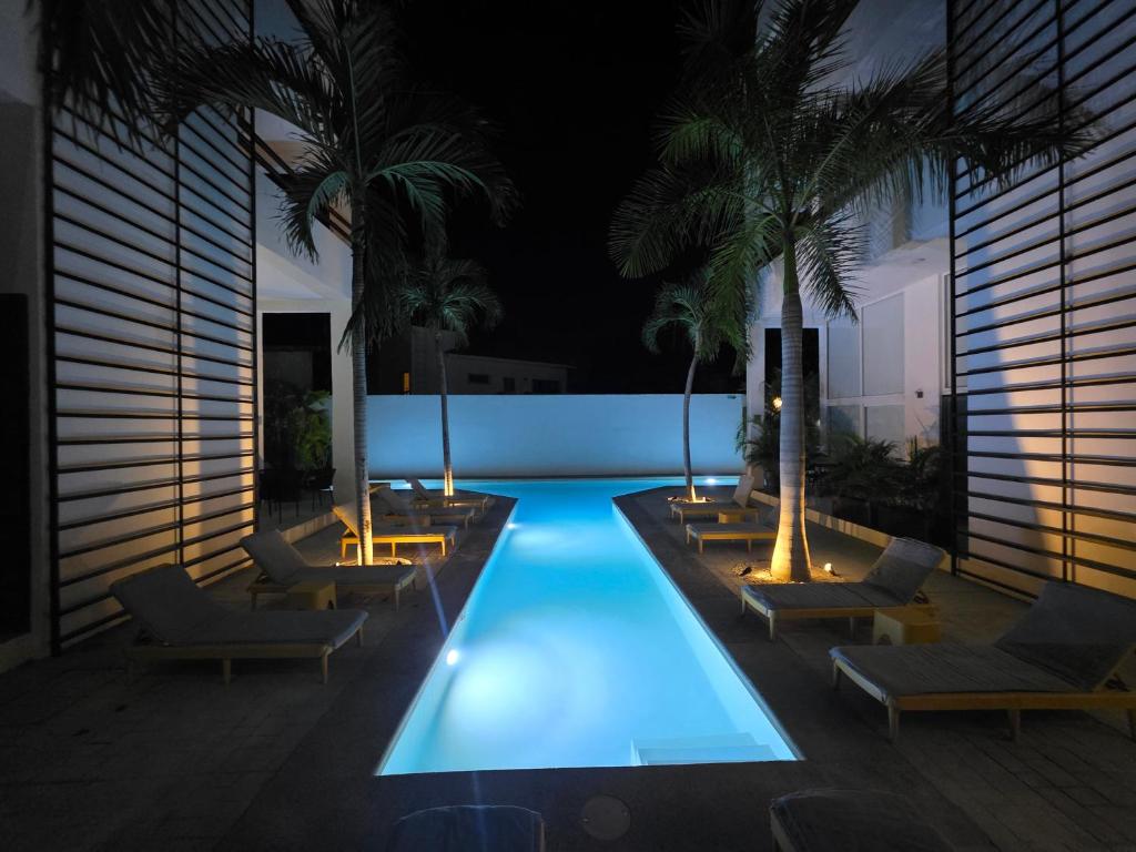 ein Pool mit Stühlen und Palmen in der Nacht in der Unterkunft Bucerias Beauty by sport park east side walk to beach in Bucerías