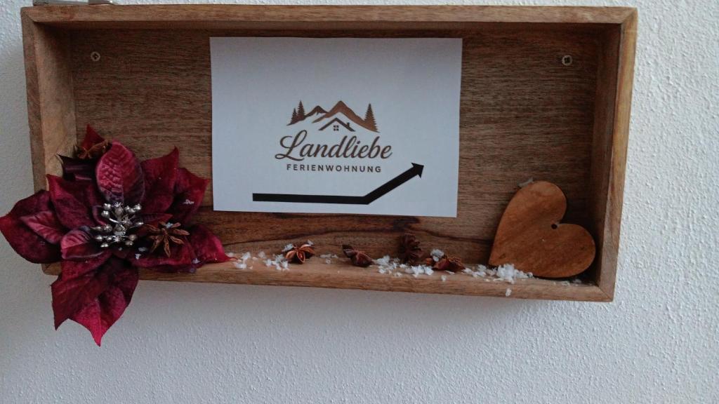 un cadre en bois avec une photo et un panneau de la Saint-Valentin dans l'établissement Ferienwohnung Landliebe, à Pinswang
