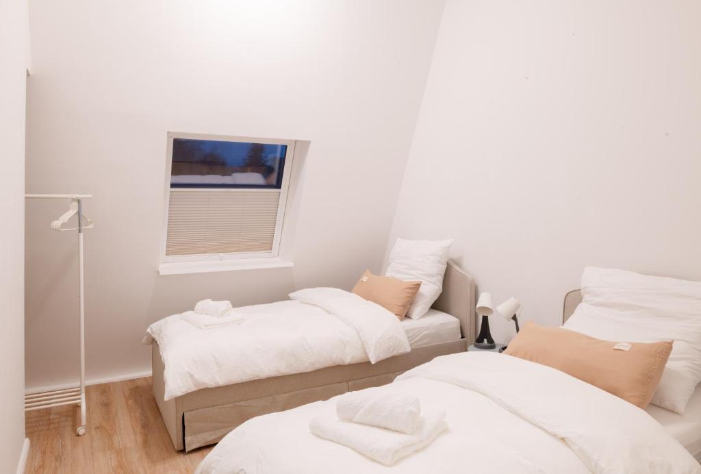 a white room with two beds and a window at Design-Apartment Worpswede in Worpswede