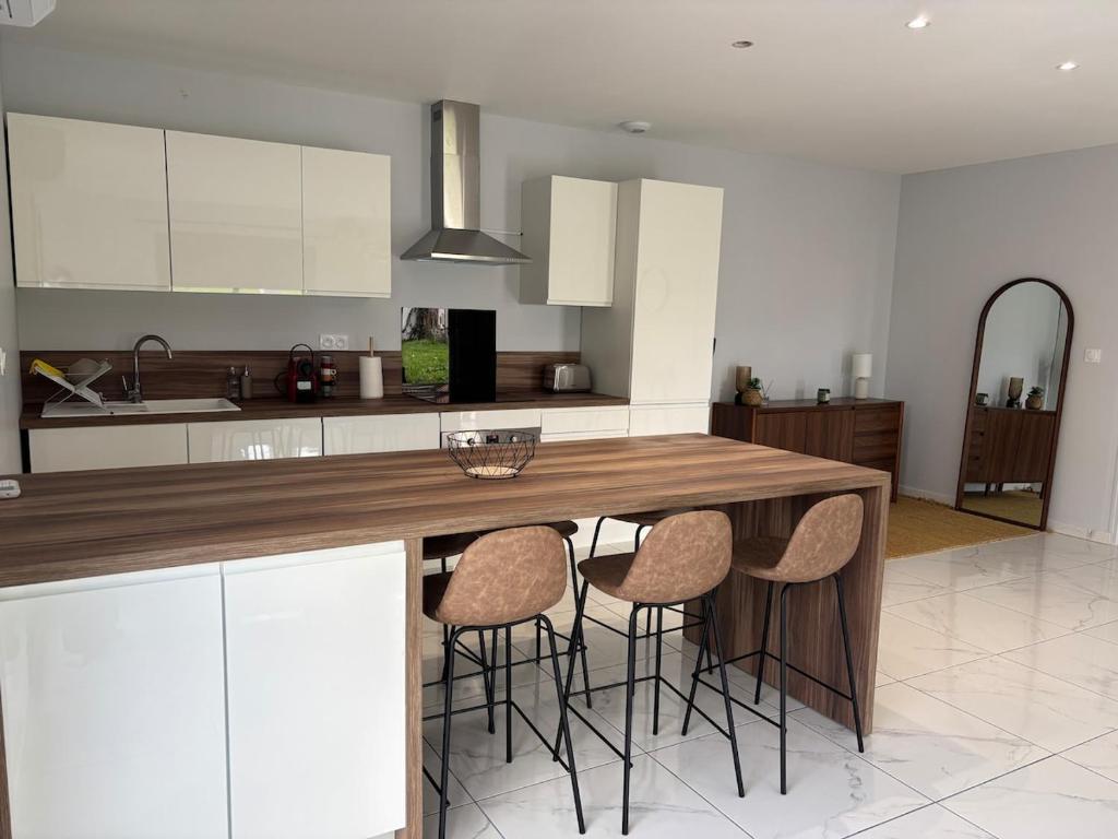 a kitchen with a wooden table and stools at Maison neuve 2 chambres entre Dordogne et Corrèze in Terrasson-Lavilledieu