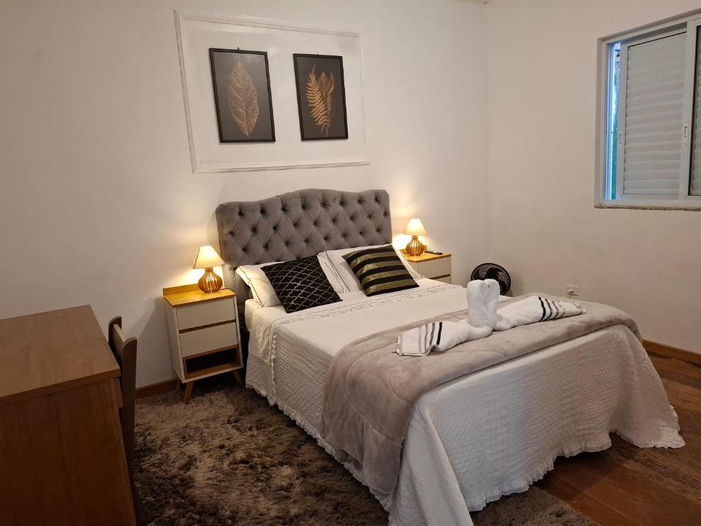 una camera da letto con un letto grande e due comodini di AP 01 Itacolomy com piscina aquecimento solar a Ouro Preto