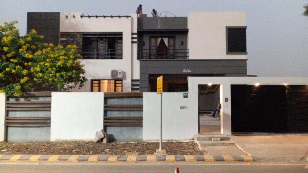 ein großes weißes Haus mit einer Tür davor in der Unterkunft Holiday One Hotel & Suites in Karatschi