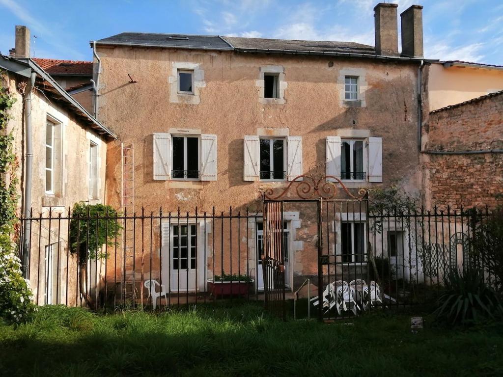 an old building with a fence in front of it at Grande maison de ville avec jardin Valence en Poitou pour 8 à 14 personnes in Couhé-Verac