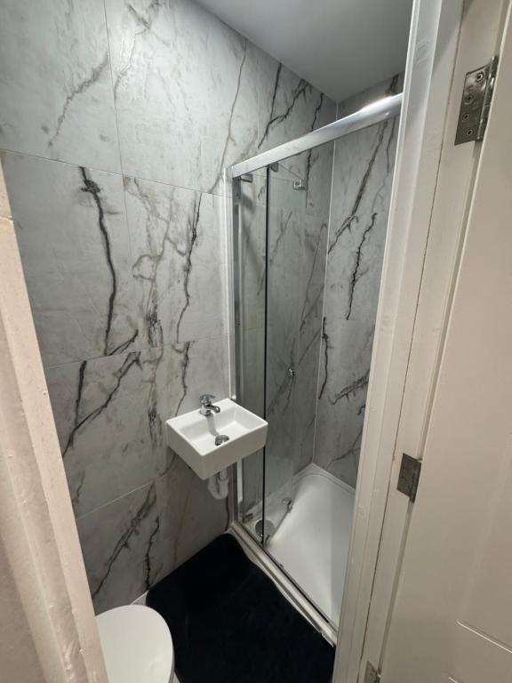 a bathroom with a sink and a shower and a toilet at Cozy en-suite 15 minutes from Heathrow Airport by car in South Ruislip Station