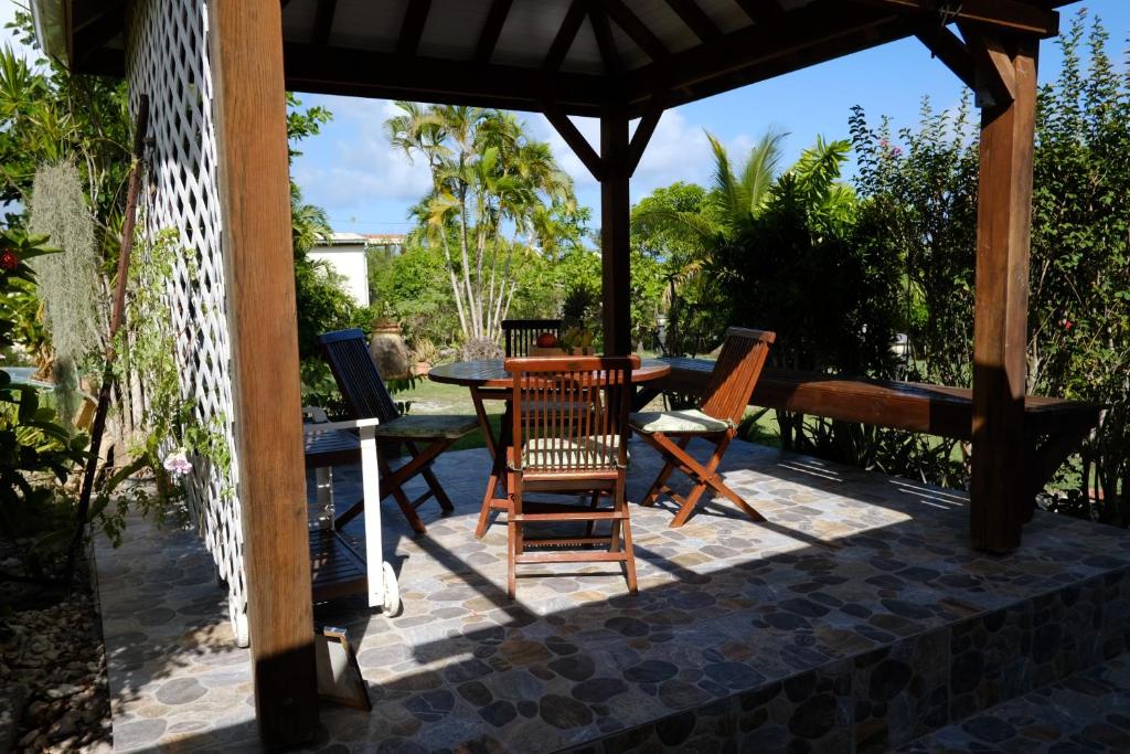 a patio with a table and chairs under a gazebo at Lantana in Sainte-Anne