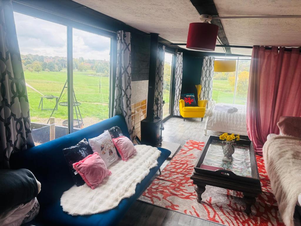 a living room with a blue couch and a window at Outlook farm cabin firepit in Hertford