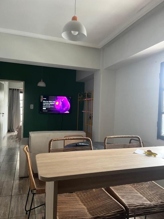 Depto San Lorenzo y Alberdi في سان ميغيل دي توكومان: غرفة طعام مع طاولة وكراسي وتلفزيون