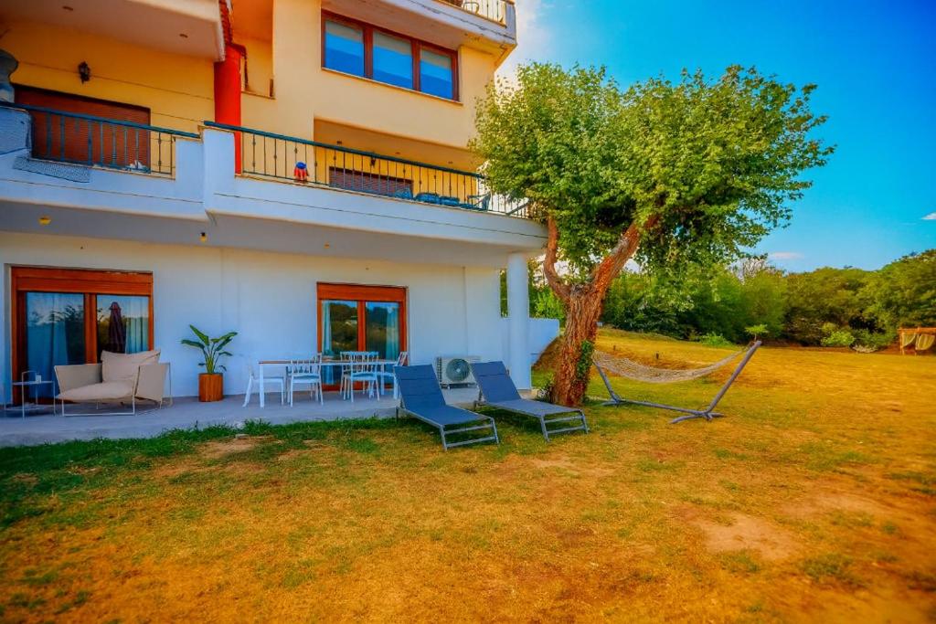 a house with chairs and a tree in the yard at Oasis Acropolis Serres With Parking Next to Center in Serres