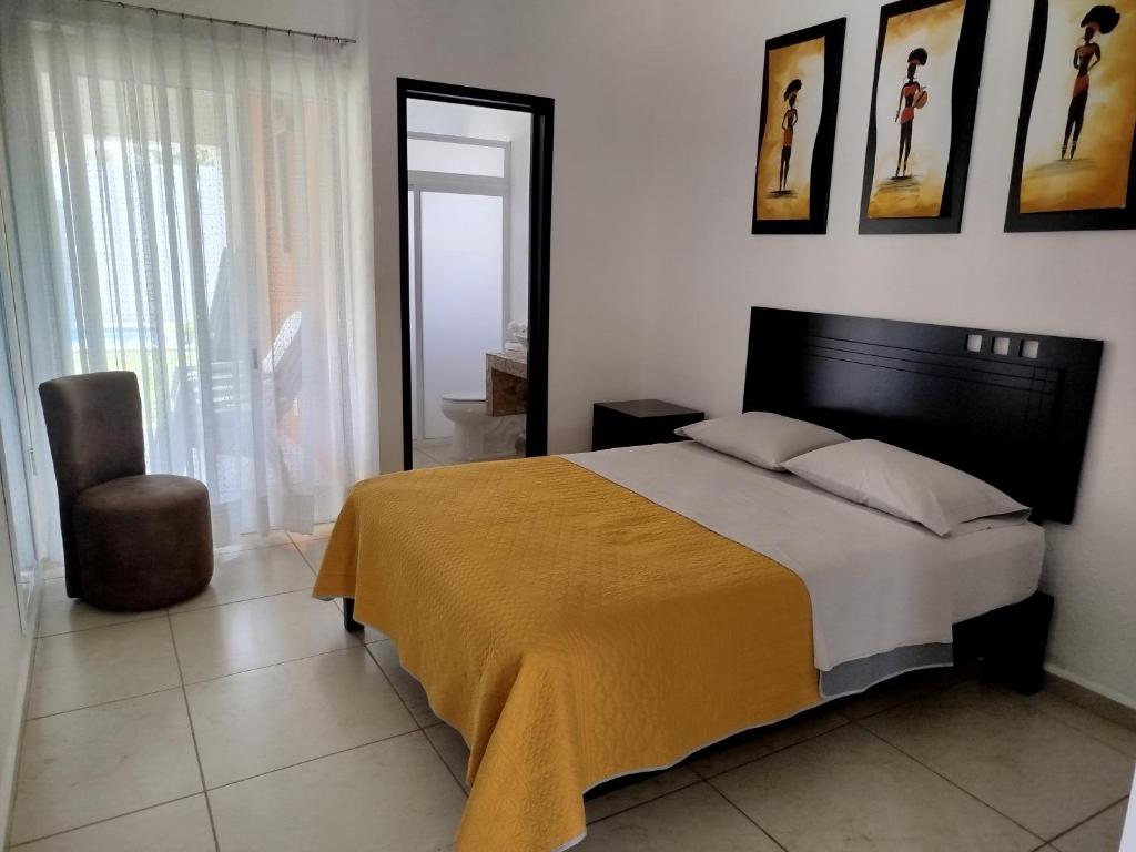 une chambre avec un grand lit et une chaise dans l'établissement CASA MYAA, casa para noche, día, fin de semana, semana y mes, à Cuernavaca
