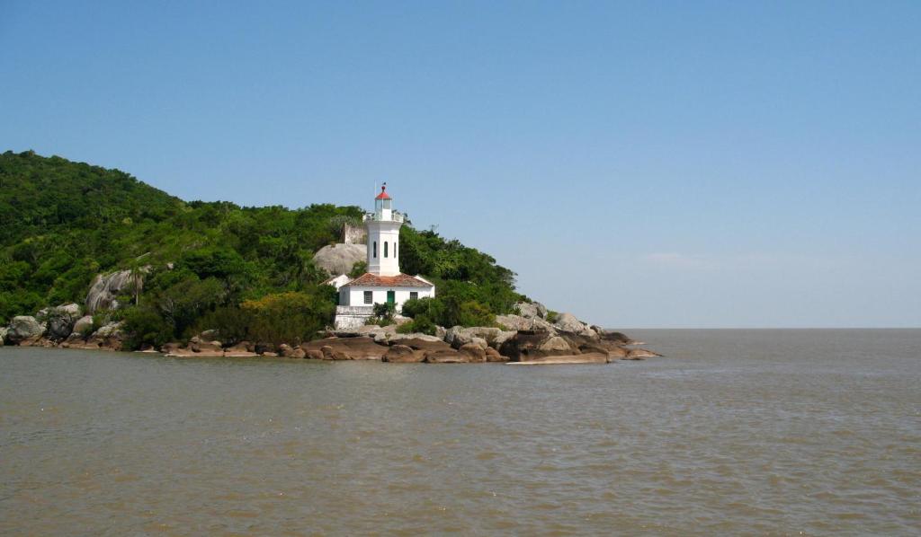 a lighthouse on an island in the water at Apto. Praia do Forte Cabo Frio in Cabo Frio