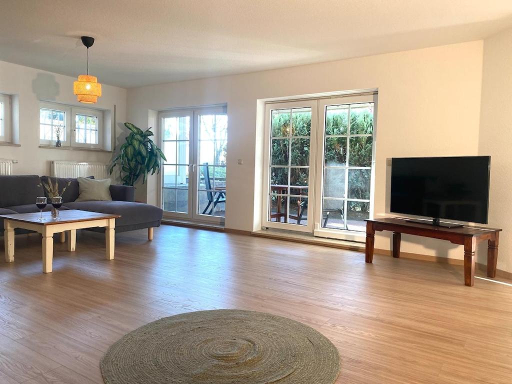 ein Wohnzimmer mit Flachbildfernseher und Couch in der Unterkunft Ferienwohnung Am Steinberg in Nauendorf