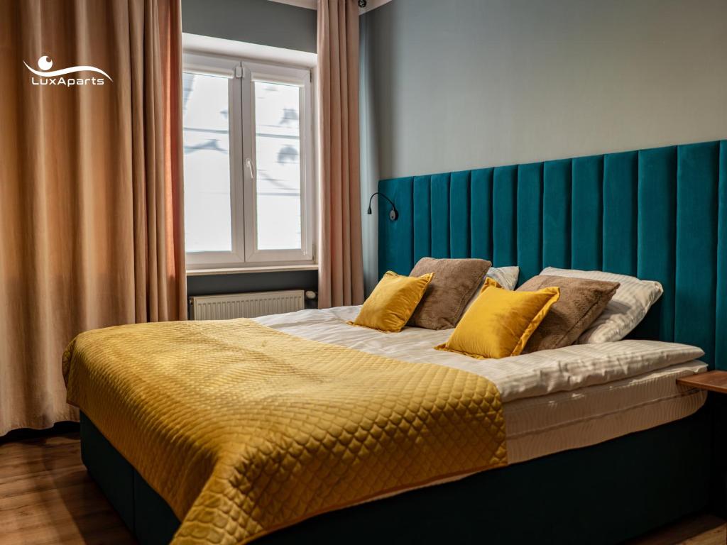 una camera da letto con un letto grande con cuscini gialli di LuxApart 9, Lublin, Stare Miasto, Plac Zamkowy a Lublino