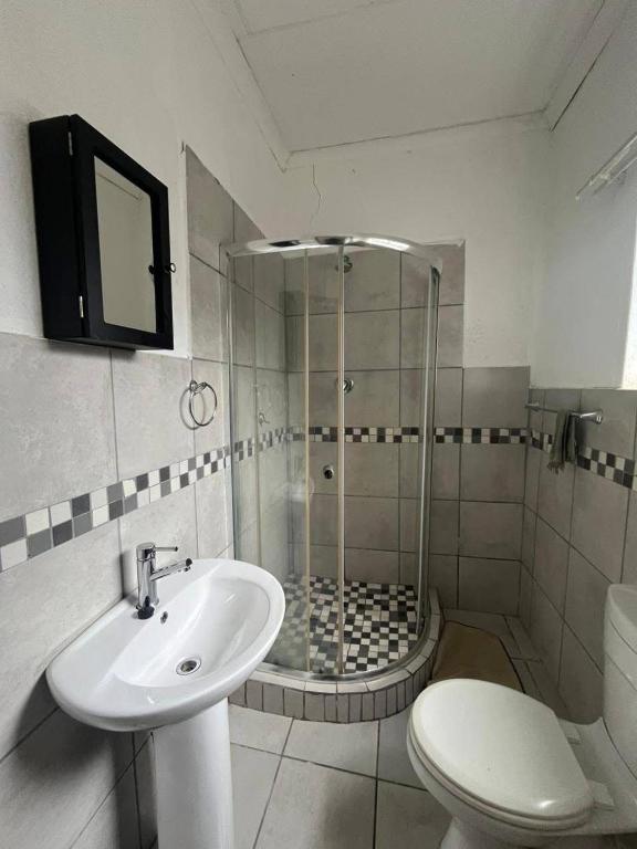 Un baño con ducha, lavabo e inodoro. en Makers lodge Bnb, en Nelspruit
