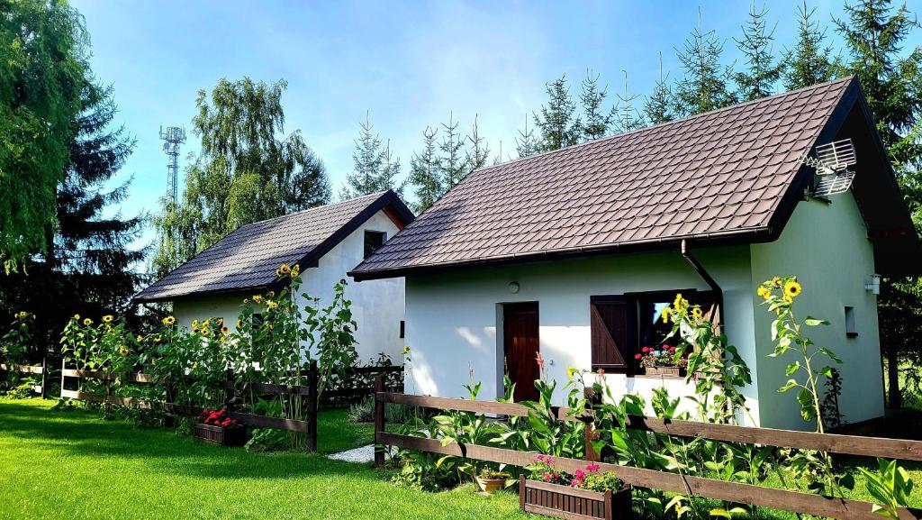 ein kleines weißes Haus mit braunem Dach in der Unterkunft Sielsko Anielsko Uniejów- domki całoroczne in Uniejów