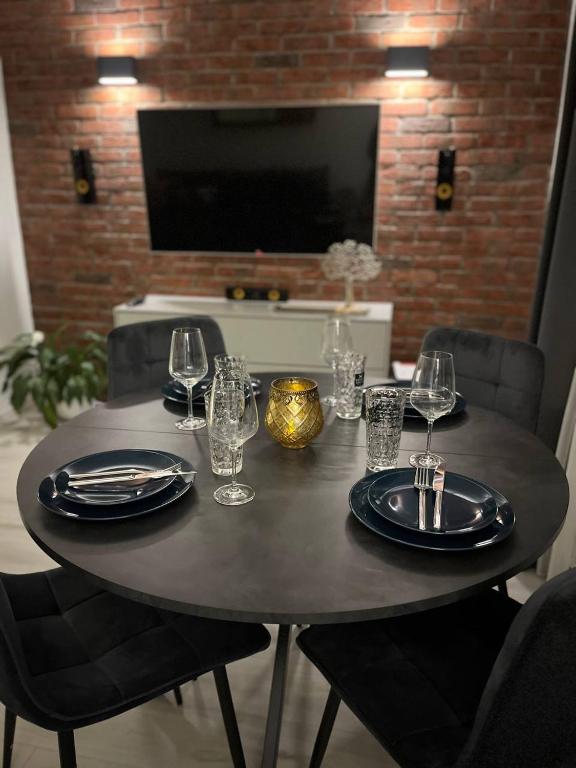 une table avec des assiettes, des verres et une télévision dans l'établissement Zentrale Wohnung 1OG mit WLAN & Kaffee, à Paderborn