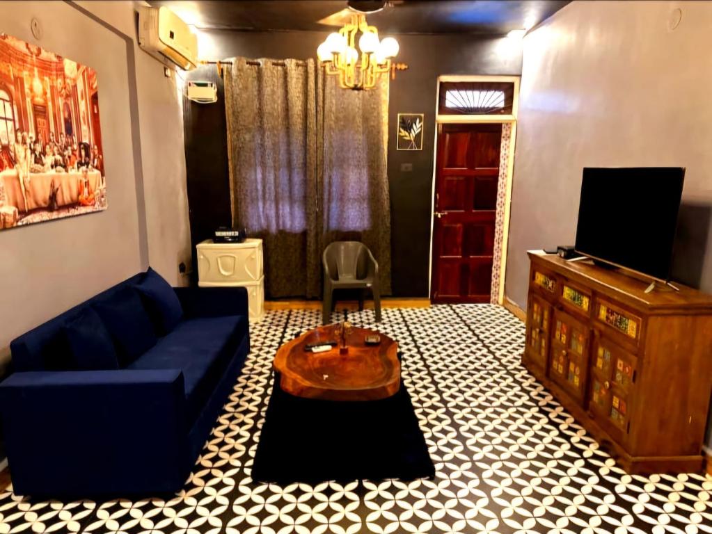 un salon avec un canapé bleu et une table dans l'établissement Goan Cozy 2 Bedroom Abode, à Calangute
