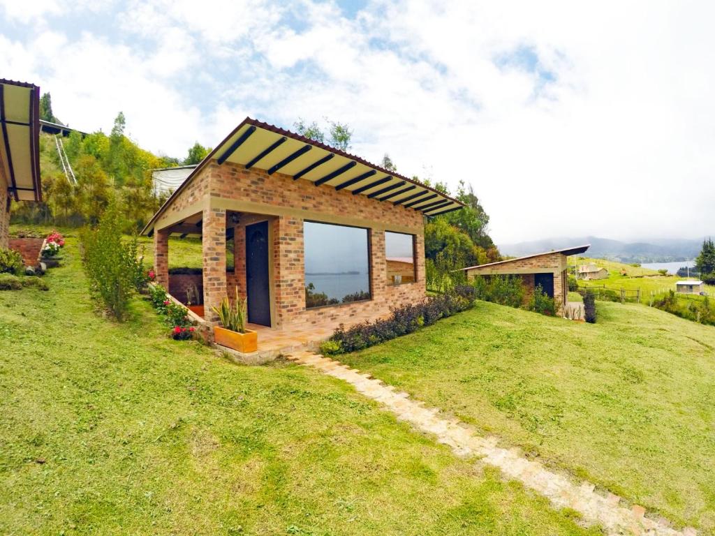une petite maison au sommet d'une colline herbeuse dans l'établissement Cabaña Luz de Luna, à Cuítiva