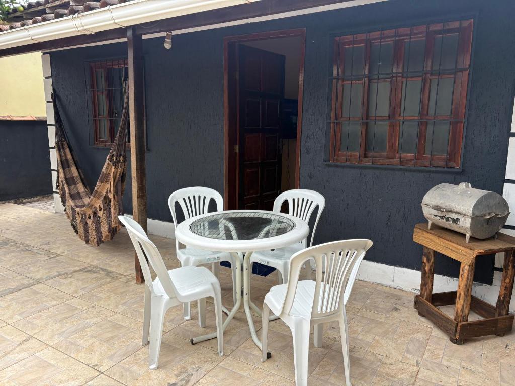 a white table and chairs on a patio at Casa simples e aconchegante em Unamar - Cabo Frio in Tamoios