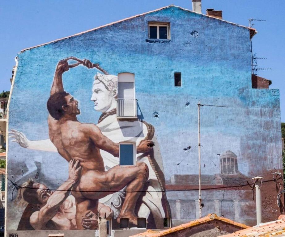 une peinture murale sur le côté d'un bâtiment dans l'établissement Superbe maison d artiste avec patio centre ville, à Sète