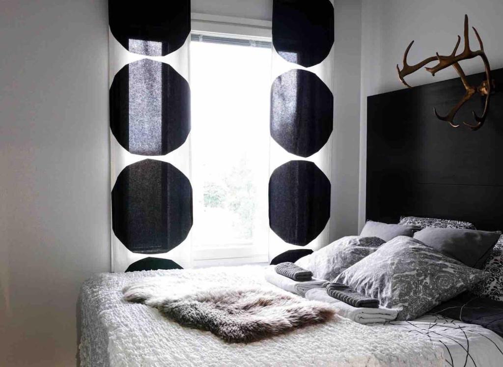 une chambre avec un lit avec une grande fenêtre dans l'établissement Compact apartment, à Rovaniemi