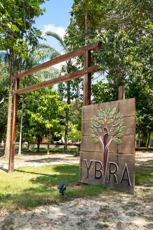 a sign with a tree on it in a park at Ybyra Pousada de Selva in Careiro