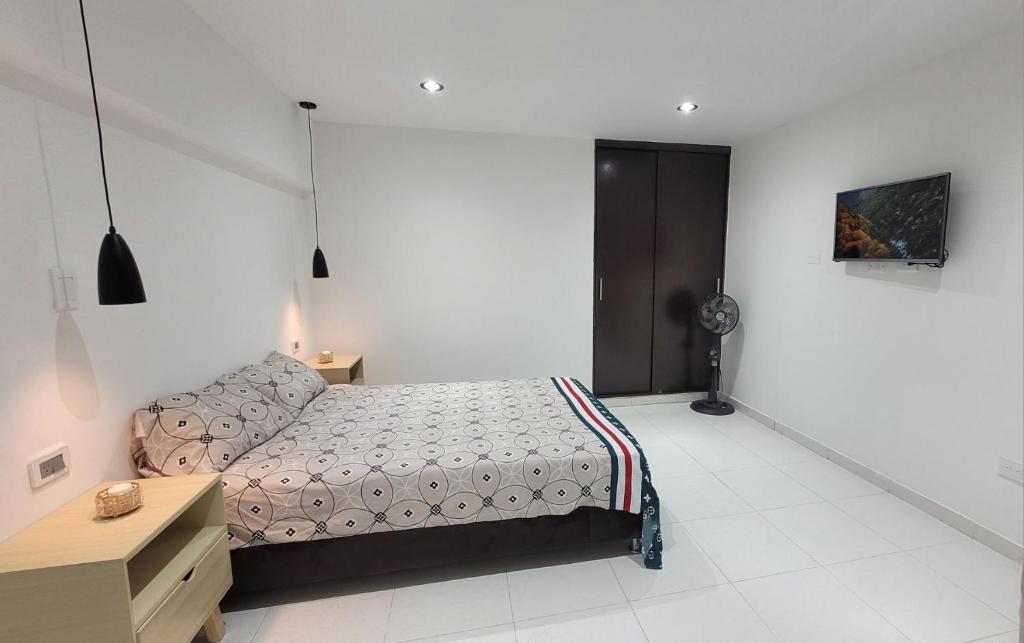 a bedroom with a bed and a dresser in it at Apartaestudio PA-TY in Cali