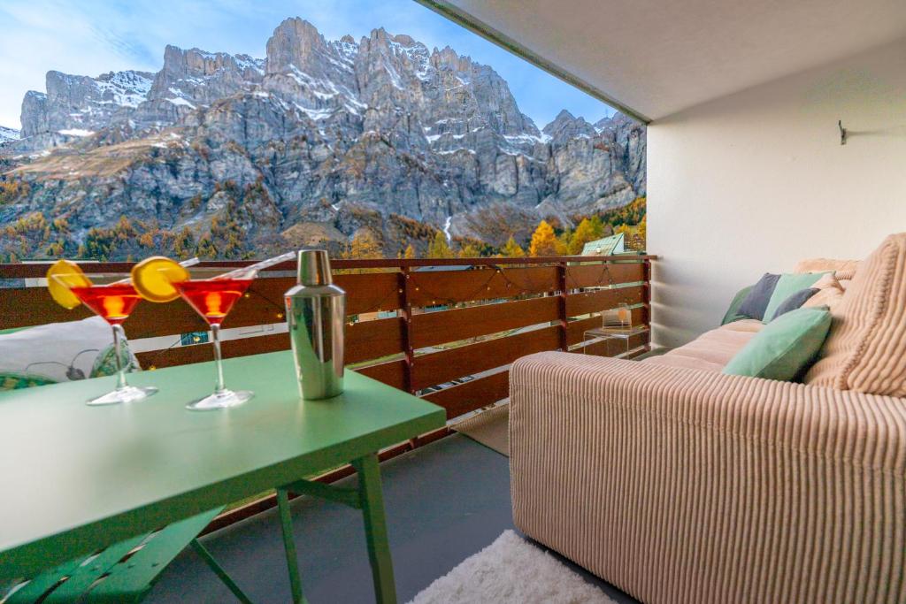 - un balcon avec une table et deux verres de vin dans l'établissement Le Belvédère de Loèche, à Loèche-les-Bains