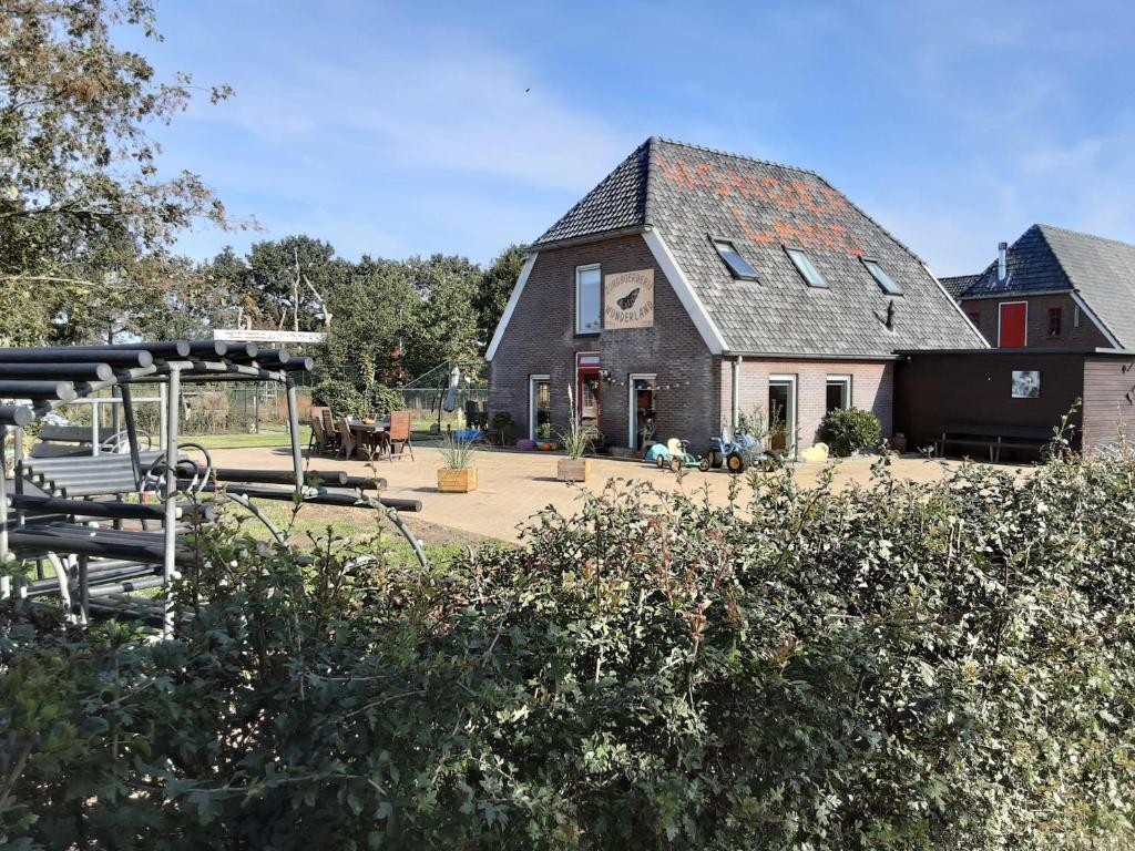 a large house with a playground in front of it at Vakantiewoning Stuifzand in Stuifzand