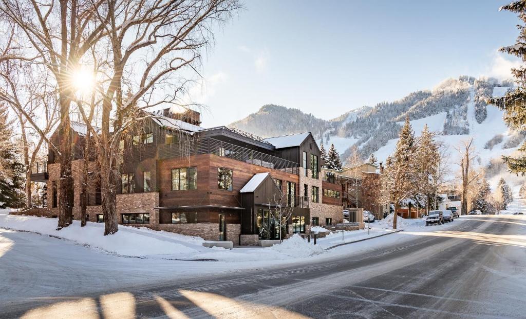 - un bâtiment dans une rue enneigée avec une montagne dans l'établissement Aspen St Lodge by Rove 10BR with Outdoor Amenities, à Aspen