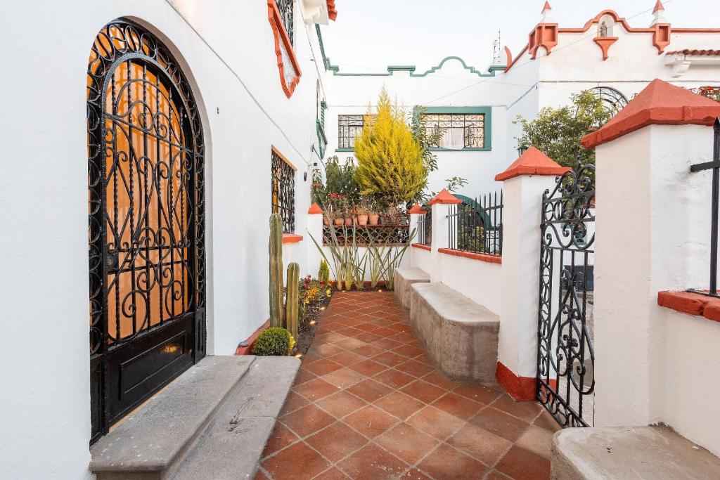 ein Innenhof mit Tor und Bänken in einem Haus in der Unterkunft Casa céntrica con 4 habitaciones y estacionamiento in Puebla