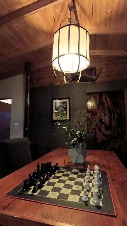 a chess board on a table with a chandelier at Cabaña El Bordoneo in Villa Yacanto