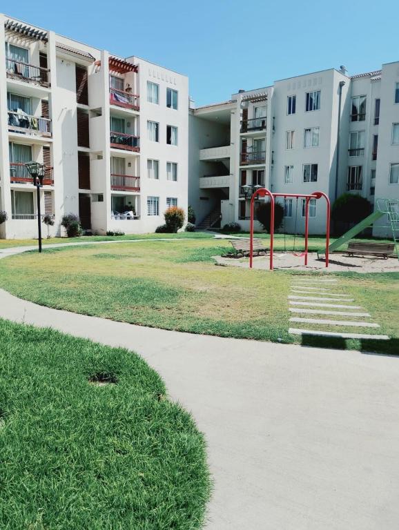 a playground in a park in front of buildings at Cómodo y espacioso departamento en La Serena in La Serena
